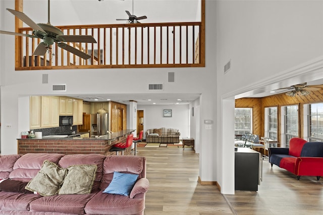 living room with ceiling fan and light hardwood / wood-style flooring