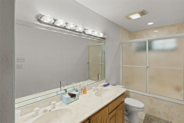 full bathroom with vanity, a textured ceiling, shower / bath combination with glass door, and toilet