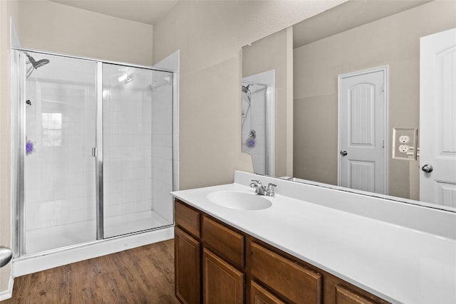 bathroom featuring hardwood / wood-style flooring, vanity, and an enclosed shower