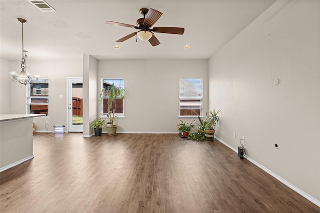 unfurnished living room with dark hardwood / wood-style floors and ceiling fan with notable chandelier