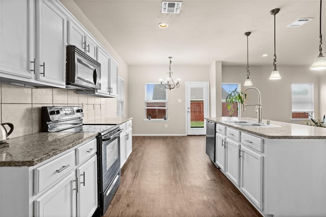 kitchen featuring sink, stainless steel appliances, an island with sink, and white cabinets