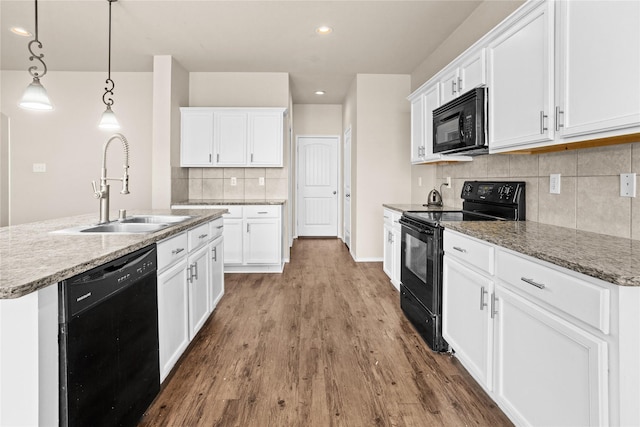 kitchen featuring sink, pendant lighting, white cabinets, and black appliances