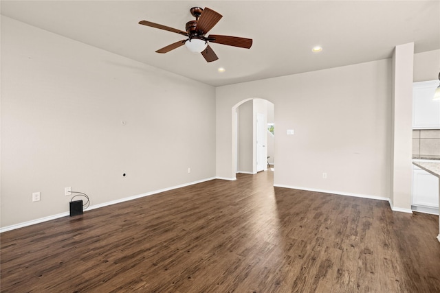 unfurnished living room with dark wood-type flooring and ceiling fan