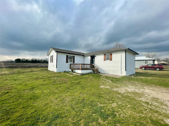 view of front of property with a wooden deck and a front yard