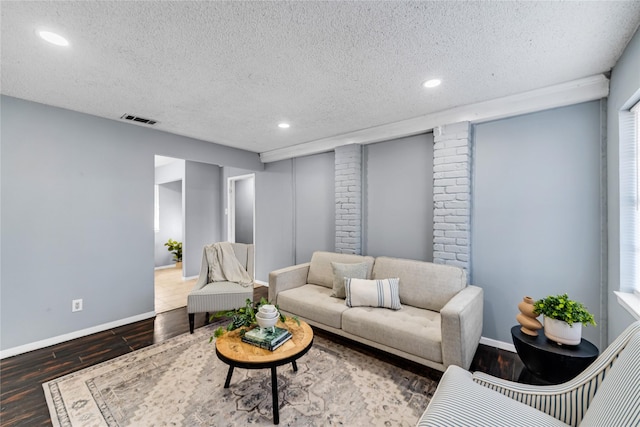 living room featuring wood-type flooring and a textured ceiling