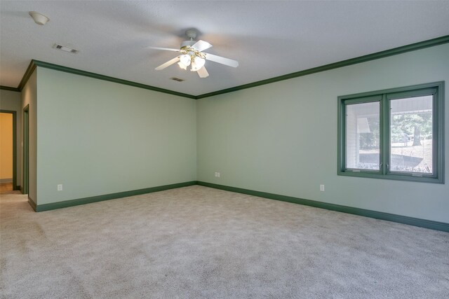 spare room with light carpet, crown molding, a textured ceiling, and ceiling fan