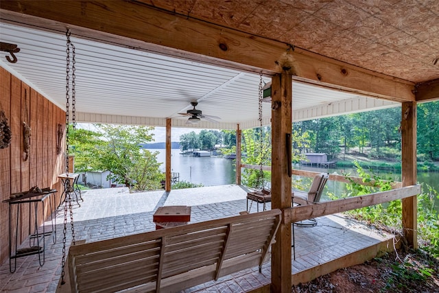 view of patio with a water view and ceiling fan