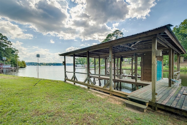 dock area with a water view and a lawn