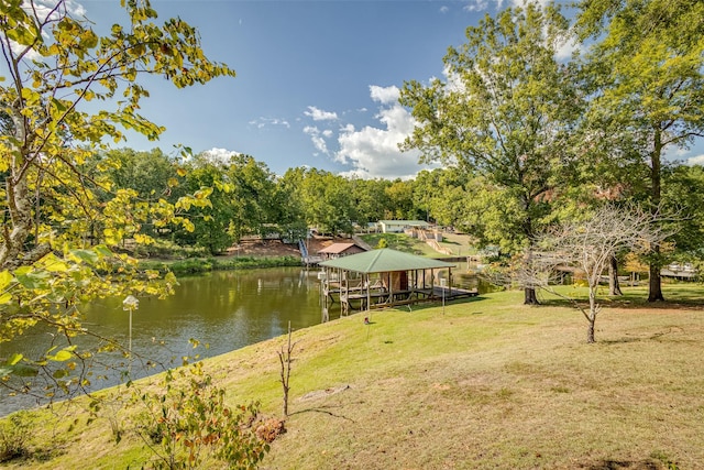 dock area with a lawn and a water view