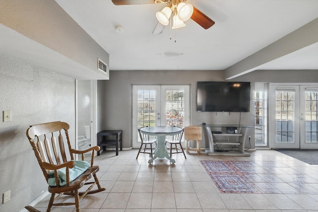 living area featuring light tile patterned floors, visible vents, a wealth of natural light, and french doors