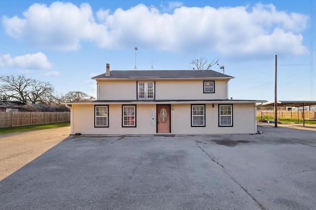 rear view of house with a patio, a chimney, and fence