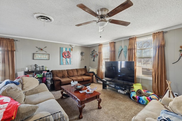 carpeted living area with a ceiling fan, a textured ceiling, visible vents, and crown molding