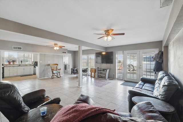 living room featuring french doors, visible vents, and light tile patterned flooring