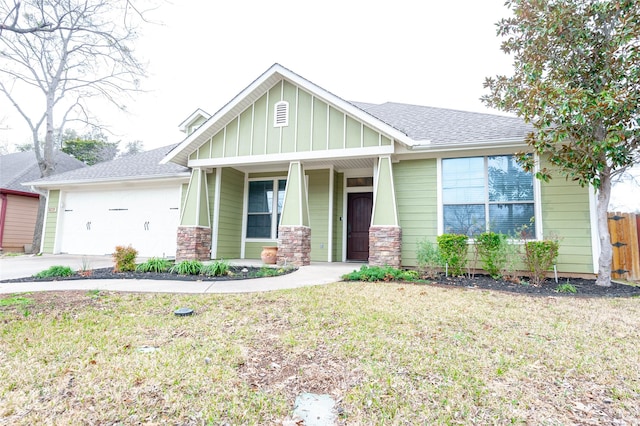 view of front of property with a porch, a garage, and a front lawn