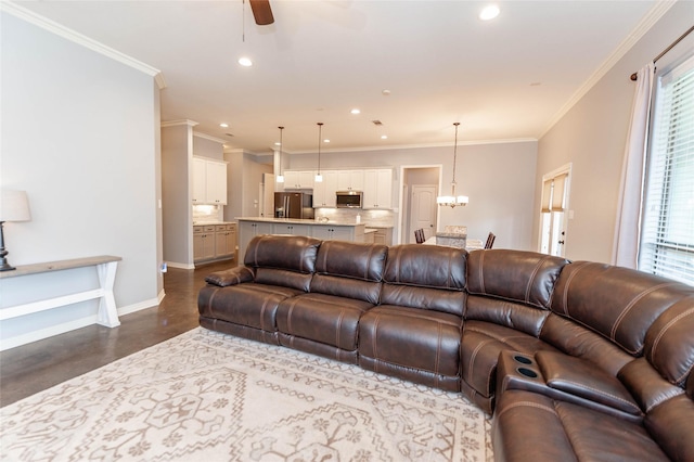 living room featuring crown molding and ceiling fan with notable chandelier