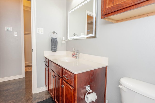 bathroom with vanity, toilet, and concrete floors