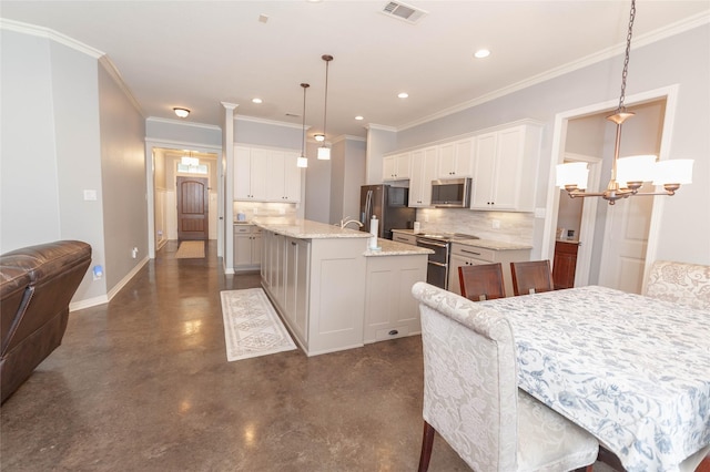 kitchen with white cabinetry, stainless steel appliances, a kitchen breakfast bar, a center island with sink, and decorative light fixtures