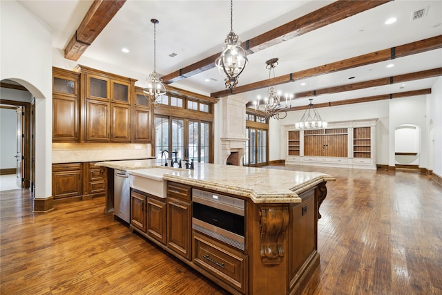 kitchen featuring hanging light fixtures, dark hardwood / wood-style floors, a spacious island, decorative backsplash, and stainless steel dishwasher