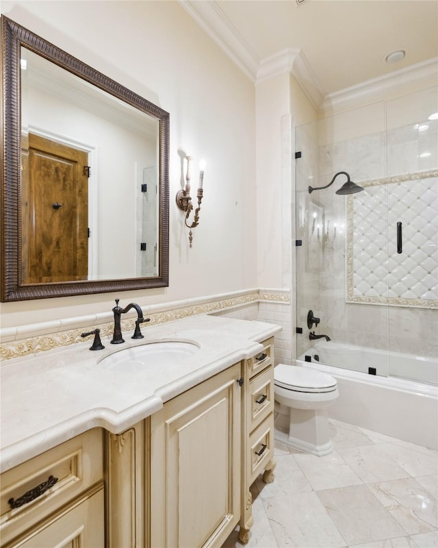 full bathroom featuring combined bath / shower with glass door, tile walls, vanity, toilet, and crown molding