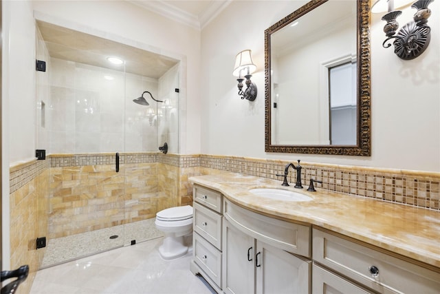 bathroom with a shower with shower door, tile walls, ornamental molding, vanity, and toilet