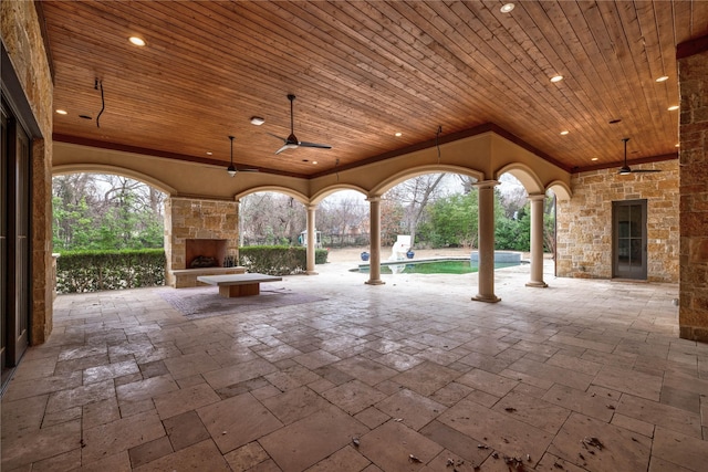 view of patio with ceiling fan and an outdoor stone fireplace