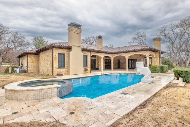 view of pool with a patio and an in ground hot tub