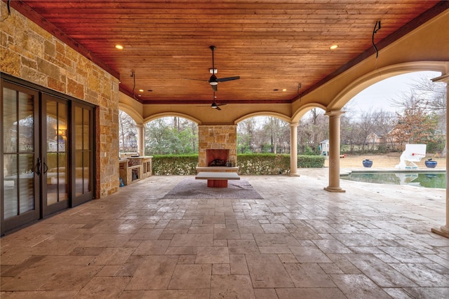 view of patio / terrace with ceiling fan and an outdoor stone fireplace