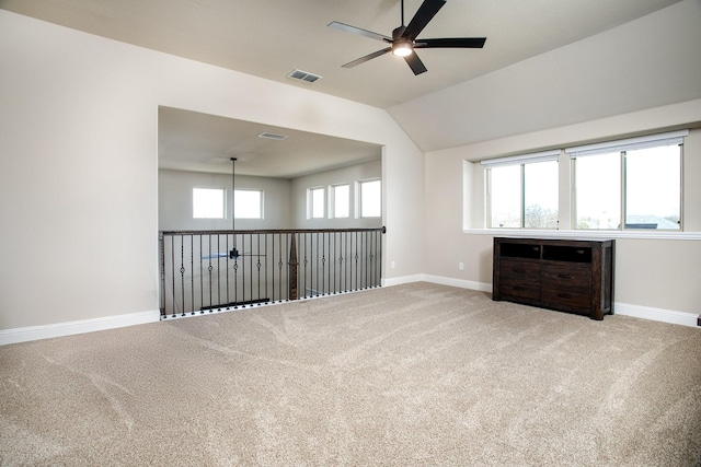 empty room featuring lofted ceiling, carpet floors, and ceiling fan