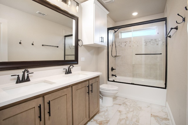 full bathroom featuring enclosed tub / shower combo, vanity, and toilet