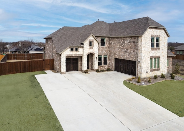 french country inspired facade featuring a garage and a front yard