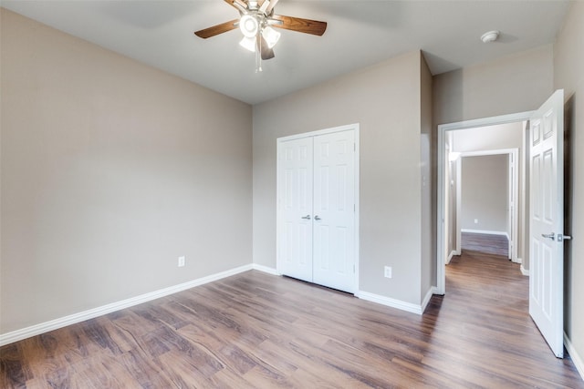 unfurnished bedroom featuring hardwood / wood-style floors, ceiling fan, and a closet