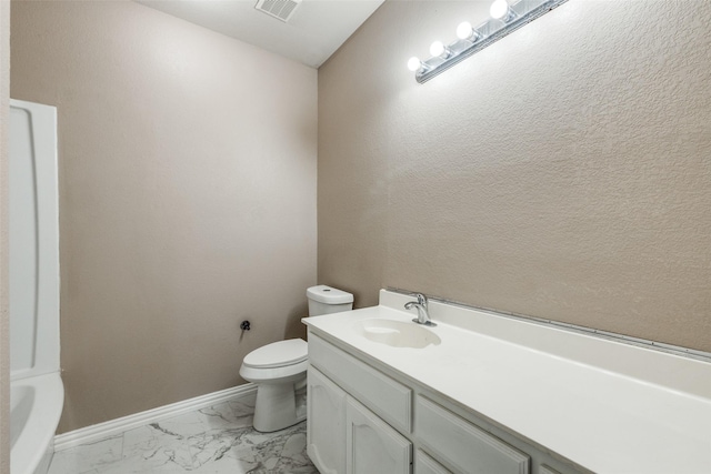 bathroom featuring vanity, a bathing tub, and toilet