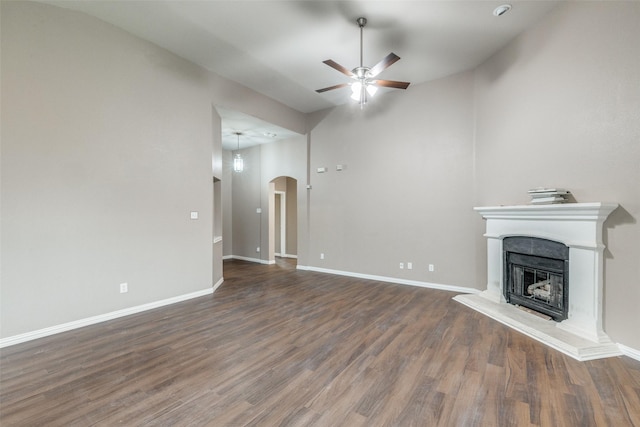 unfurnished living room with dark wood-type flooring, ceiling fan, and vaulted ceiling