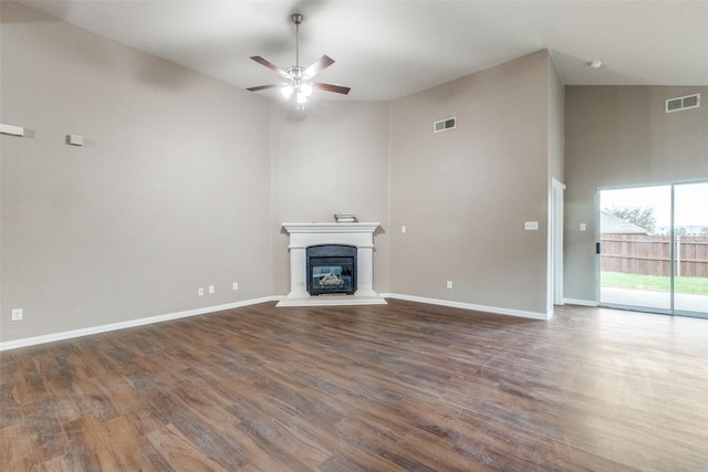 unfurnished living room featuring ceiling fan, a towering ceiling, and dark hardwood / wood-style flooring