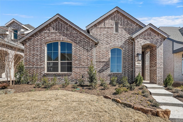 french country style house with brick siding