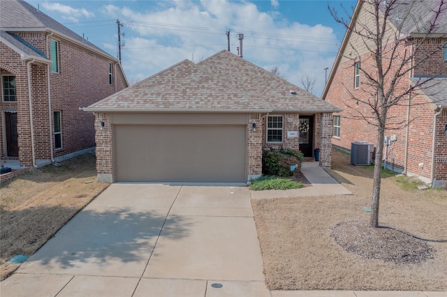 view of front of property featuring brick siding, central air condition unit, a shingled roof, a garage, and driveway