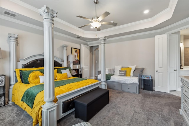 bedroom with a raised ceiling, crown molding, carpet floors, and ornate columns