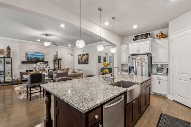 kitchen featuring pendant lighting, appliances with stainless steel finishes, sink, and white cabinets