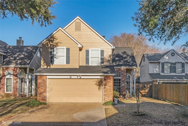 view of front of property with a garage, brick siding, driveway, and fence