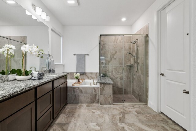 full bathroom featuring a stall shower, vanity, and a bath