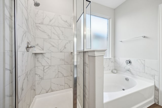 full bathroom featuring a stall shower and a bath