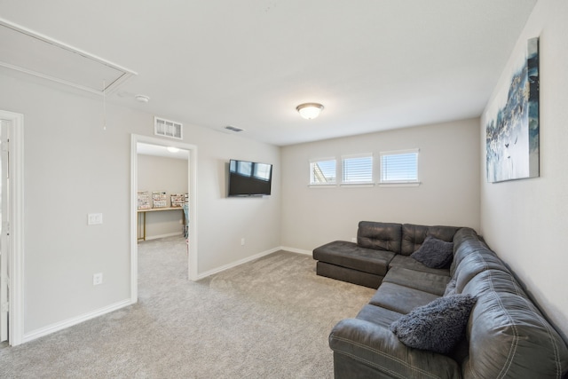 living room with visible vents, baseboards, attic access, and light colored carpet