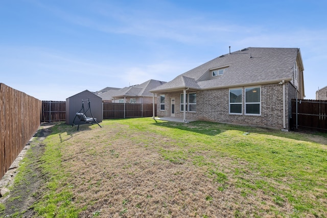 rear view of property with a patio area, brick siding, a lawn, and a fenced backyard