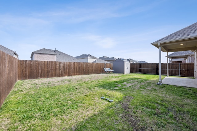 view of yard featuring a storage shed, a fenced backyard, a patio area, and an outbuilding