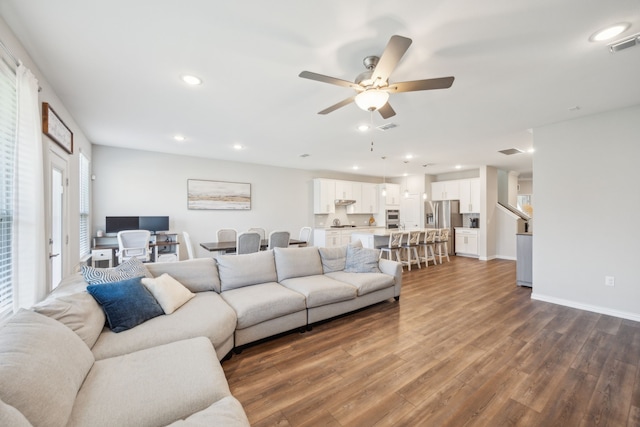 living room with baseboards, wood finished floors, visible vents, and recessed lighting