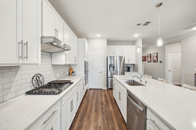 kitchen featuring under cabinet range hood, stainless steel appliances, a sink, white cabinetry, and decorative light fixtures