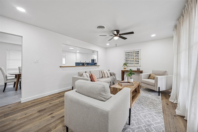 living room with baseboards, visible vents, a ceiling fan, wood finished floors, and recessed lighting