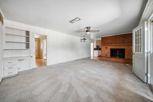 unfurnished living room featuring ceiling fan, light colored carpet, and a fireplace