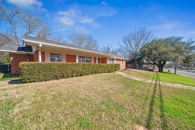 ranch-style house with a front yard and central air condition unit