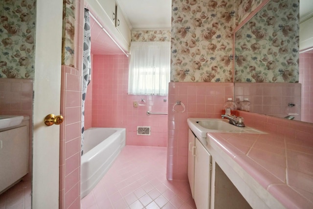 bathroom featuring a tub to relax in, vanity, tile patterned flooring, and tile walls